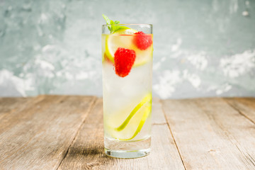 Sweet summer cocktail with raspberry and lime on the rustic background. Selective focus. Shallow depth of field.