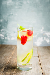 Sweet summer cocktail with raspberry and lime on the rustic background. Selective focus. Shallow depth of field.