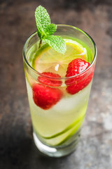 Sweet summer cocktail with raspberry and lime on the rustic background. Selective focus. Shallow depth of field.