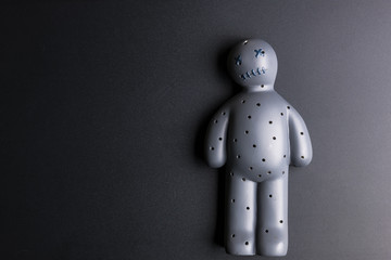 Obraz premium Voodoo Doll on a black background with dramatic lighting.