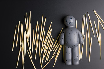 Voodoo Doll on a black background with dramatic lighting.