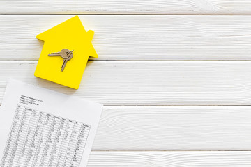 Tax for property accounting with house figure, keys and table on white wooden background top view...