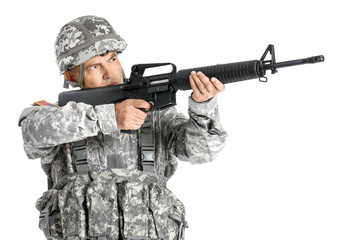 Mature male soldier aiming from assault rifle on white background