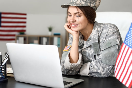 Young Female Soldier Working With Laptop In Headquarters Building