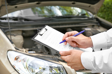 Insurance agent near damaged car outdoors, closeup