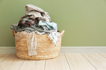 Basket with dirty laundry on floor - obrazy, fototapety, plakaty