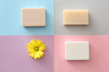 Different soap with flower on color background