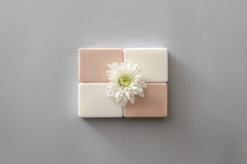 Different soap with flower on grey background