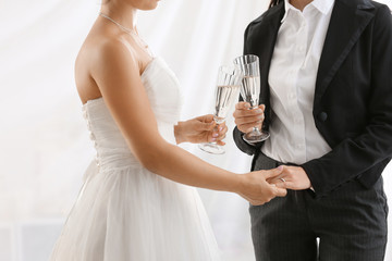 Beautiful lesbian couple with glasses of champagne during wedding ceremony, closeup
