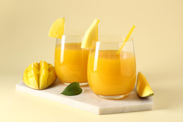 Fototapeta premium Glasses of tasty mango juice on color background