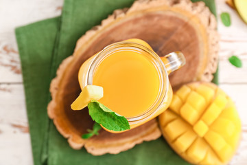Mason jar of fresh mango juice on table
