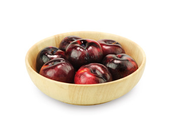Group fresh plum on a wood plate isolated on white background.