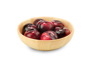 Group fresh plum on a wood plate isolated on white background.