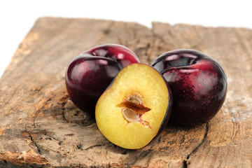 Fresh ripe plum on wood background.