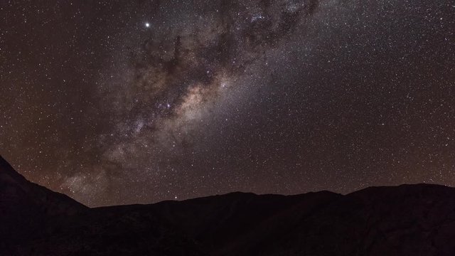 Time-lapse is showing a Milky Way center rising over tent in the chilean Andes near Paso de Agua Negra.