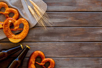Octoberfest frame. Pretzels and beer on dark wooden background top view space for text