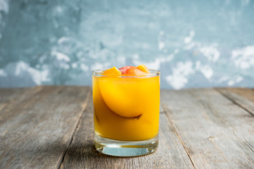 Fresh peach beverage in old fashioned glass on the rustic background. Selective focus.