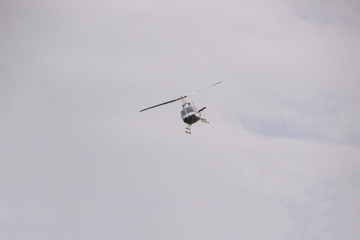 Fototapeta na wymiar Flight of a helicopter with a cloudy gray background in Santa Catarina.