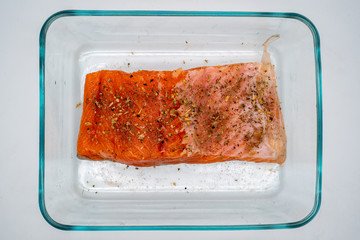 Raw salmon marinated with pepper and salt before being baked in the oven