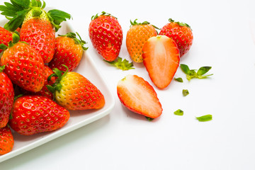 Fresh whole strawberry on plate and half cutting in white background