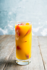 Fresh peach beverage with red ripe raspberry on the rustic background. Selective focus.