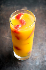 Fresh peach beverage with red ripe raspberry on the rustic background. Selective focus.