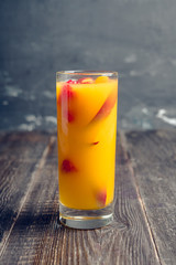 Fresh peach beverage with red ripe raspberry on the rustic background. Selective focus.