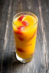 Fresh peach beverage with red ripe raspberry on the rustic background. Selective focus.