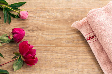 Beautiful bouquet of peonies and a towel on wooden desk.