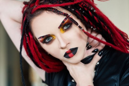 Beautiful young woman with piercing, dreads and stylish make-up.  Woman cyberpunk.