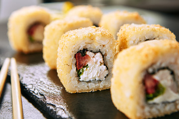 Smoked Chicken Tempura Uramaki Sushi Rolls on Black Background