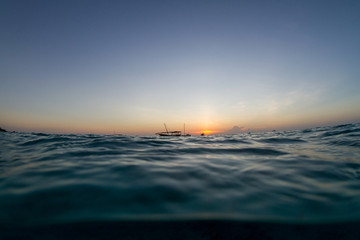 Sail boat on a calm ocean at sunset