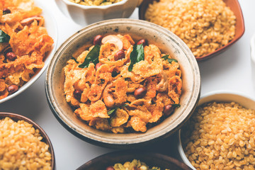 Group of Cornflake and Thick Poha Chivda or Chiwda and Chatpata Masala chana and fried crispy Moong Dal, served in a bowl. selective focus