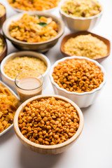 Group of Cornflake and Thick Poha Chivda or Chiwda and Chatpata Masala chana and fried crispy Moong Dal, served in a bowl. selective focus