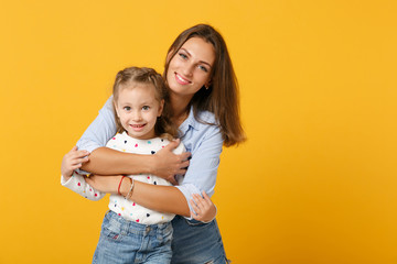 Woman in light clothes have fun with cute child baby girl 4-5 years old. Mommy little kid daughter isolated on yellow background studio portrait. Mother's Day love family parenthood childhood concept.