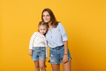 Woman in light clothes have fun with cute child baby girl 4-5 years old. Mommy little kid daughter isolated on yellow background studio portrait. Mother's Day love family parenthood childhood concept.