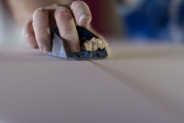 surfboard shaper close up shaping a board