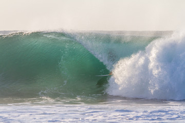 surfer getting barrelled in a huge wave