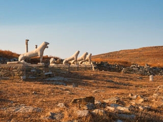 Lion statues on stone pedestals by ruins