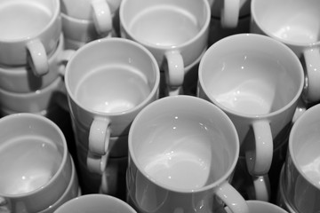 lots of white clean mugs for coffee and tea stacked on top of each other