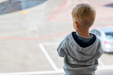 Two year old boy at the airport looking at plane