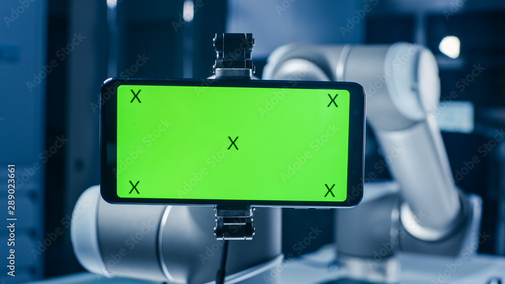 Leinwandbilder Robot Arm Holding Green Mock-up Screen Smartphone in Landscape Mode. Industrial Robotic Manipulator End Effector Holds Mobile Phone with Chroma Key Display. 