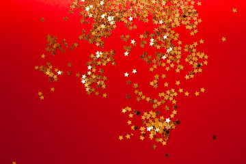 Golden star confetti in harsh light with shadow