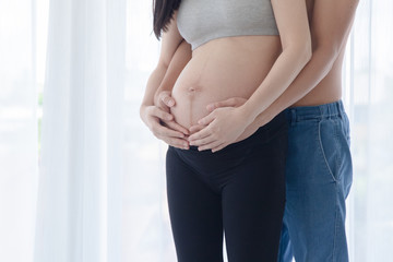 Husband hugs his pregnant wife by fully love and hope that the baby is safe when born.