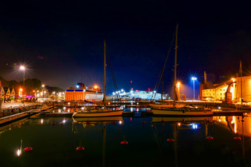 Fototapeta na wymiar Visby, Gotland, Sweden The port of Visby at night with sailboats.