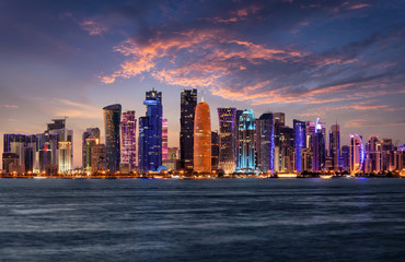Die beleuchtete Skyline von Doha im Staat von Katar am Abend nach Sonnenuntergang