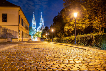 Church of St. Peter and Paul on Vysehrad. Cobbled street by night. Prague, Czech Republic