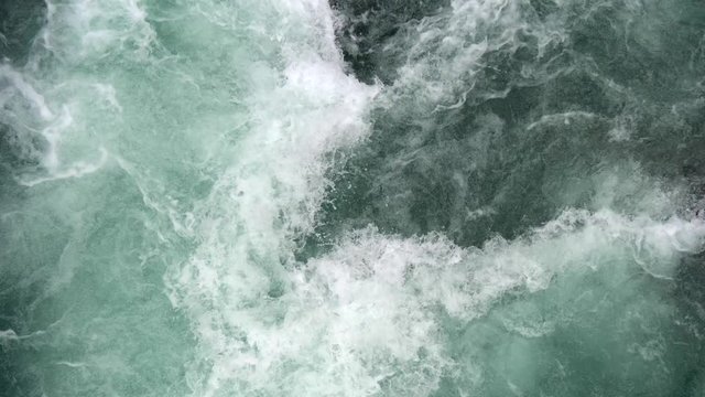 Turquoise and white water flowing violently in a powerful mountain river. View from top, 4K