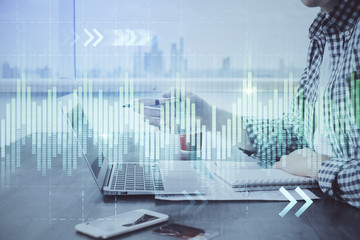 Double exposure of stock market chart with man working on computer on background. Concept of financial analysis.