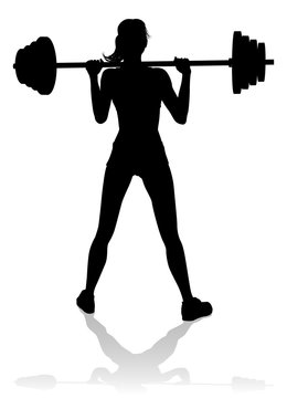 A woman in silhouette using barbell weights fitness exercise gym equipment